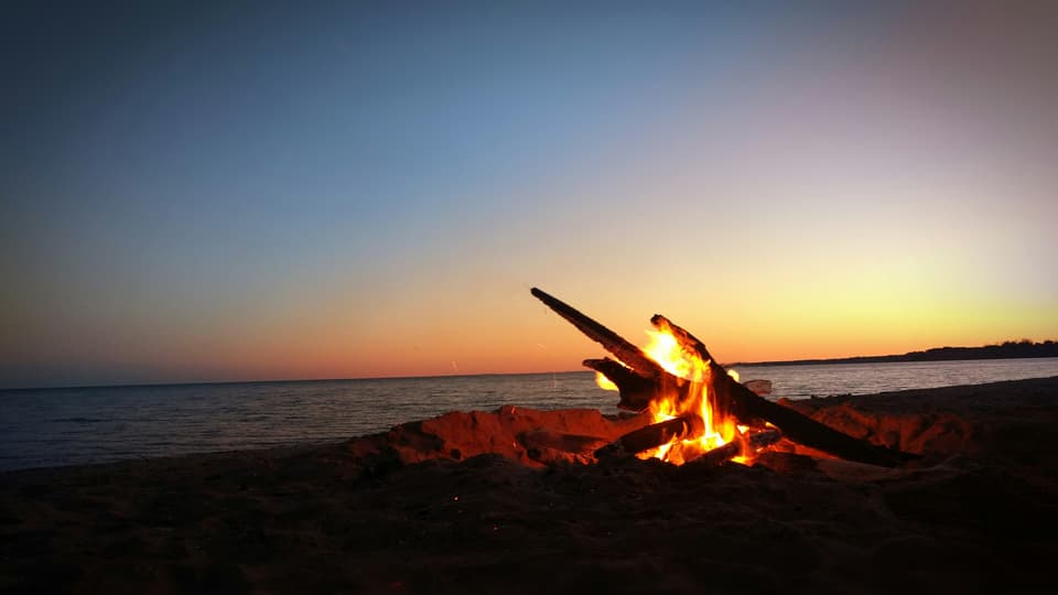 En lägereld utomhus framför havet 
